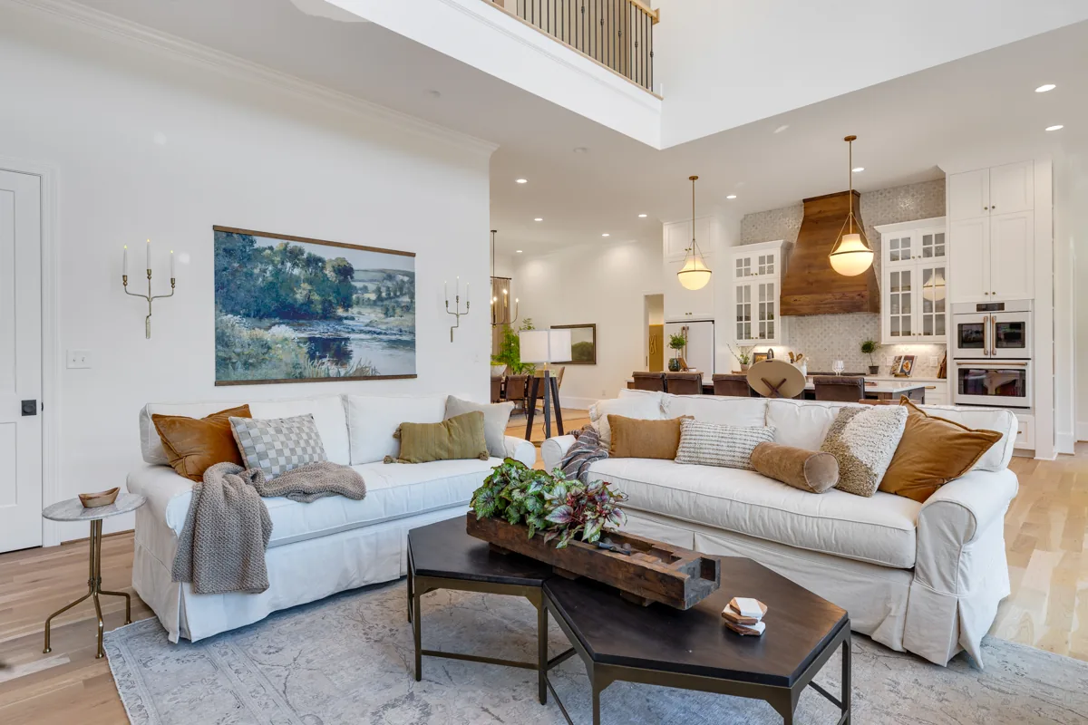 Layered neutral sofas and a dark coffee table in the open living space.